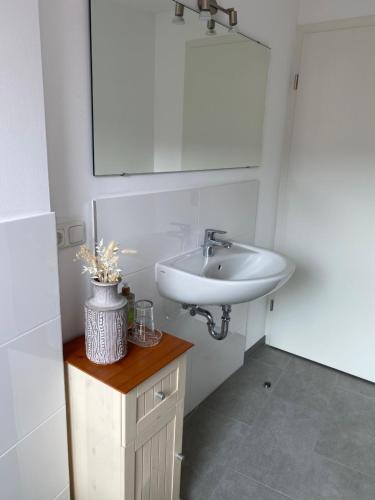 a white bathroom with a sink and a mirror at Altstadt Fereienwohnung Hameln in Hameln
