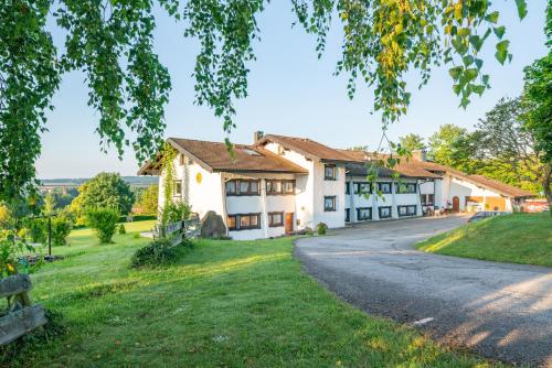 a large white house with a driveway at Landgasthaus Sonne in Freudenstadt