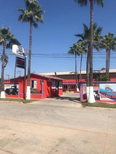 a red gas station with palm trees in front of it at COSTA MAR in Ensenada