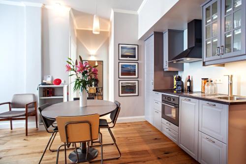 
a kitchen with a table, chairs and a refrigerator at Reykjavik Residence Apartment Hotel in Reykjavík
