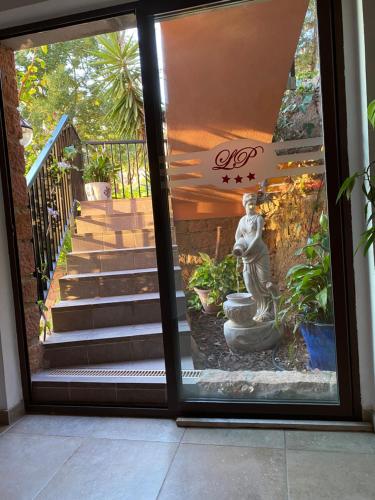 a glass door with a statue of a woman outside at Apparthotel Le Porto in Porto Ota
