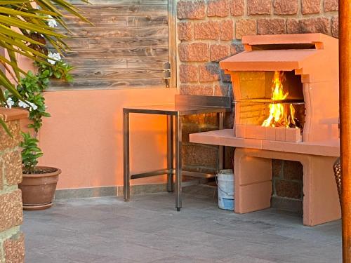 a fireplace in a patio with a table and a fire place at Apparthotel Le Porto in Porto Ota