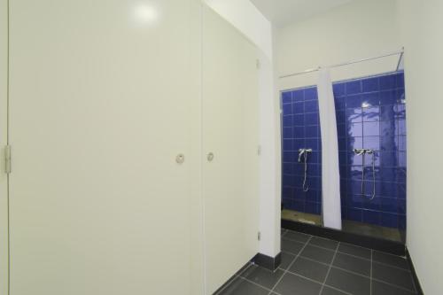 a bathroom with blue tiled walls and a mirror at Santa Maria Hostel in Funchal