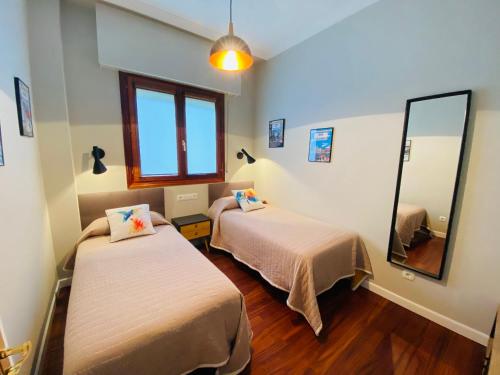 a room with two beds and a mirror at BILBAO AEROPUERTO in Derio