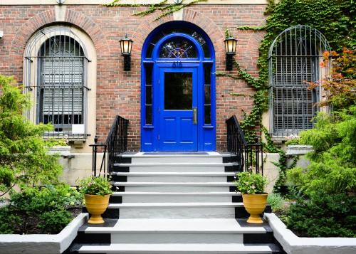 een blauwe deur op een bakstenen gebouw met een trap bij Chicago Getaway Hostel in Chicago
