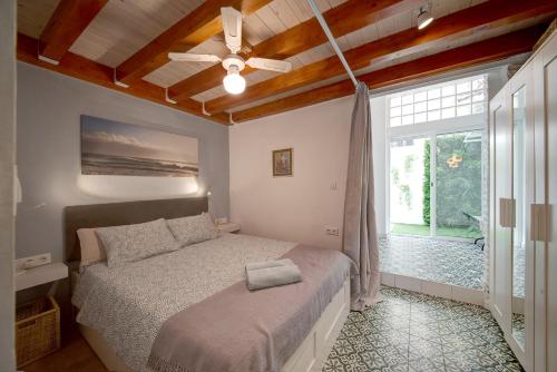 a bedroom with a bed with a ceiling fan and a window at Flamenco Beach Loft in Valencia