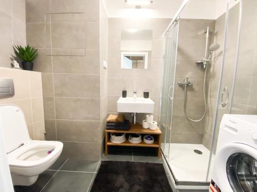 uma casa de banho com um lavatório, um WC e um chuveiro em Krásny moderný 1-izbový byt, novostavba + parking em Bratislava