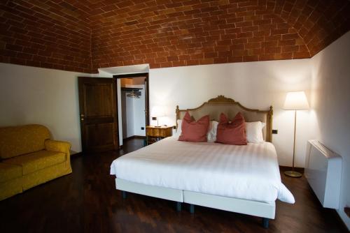 a bedroom with a white bed with red pillows at Maison Tuscany Bed&Breakfast in Sinalunga