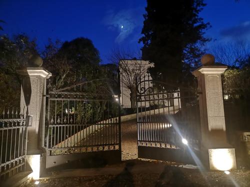 a white gate with lights on it at night at Maison Tuscany Bed&Breakfast in Sinalunga