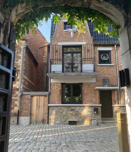 a brick building with a balcony on a brick street at Le petit béguinage in Tongeren