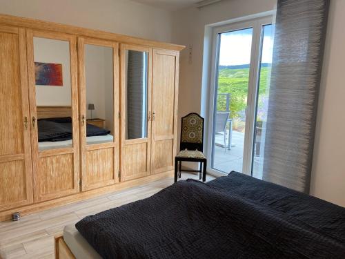 a bedroom with a bed and a sliding glass door at Ferienwohnung Weinbergblick in Mehring