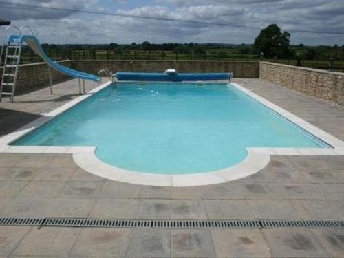 a large blue swimming pool with a slide at Whaddon Grove House in Melksham