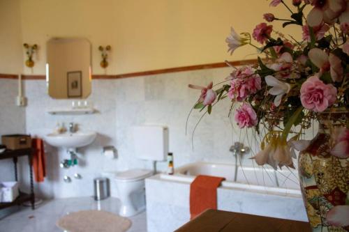 a bathroom with a tub and a vase of flowers at Dein Schloss in Schwaben in Haldenwang