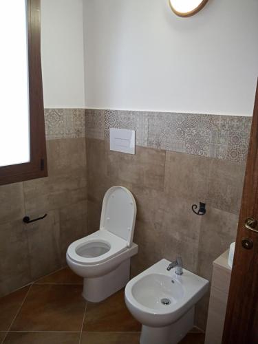 a bathroom with a toilet and a sink at CASA RURALE IMPASTATO in Montevago