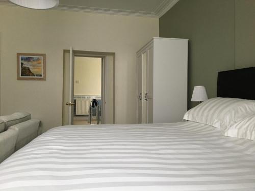 a bedroom with a large white bed and a couch at Kings B&B in South Molton
