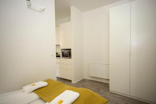 a white kitchen with white cabinets and a yellow towel at Zentral gelegene, helle Studio Apartments in Nürnberg