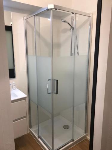 une cabine de douche avec une porte vitrée dans une salle de bain dans l'établissement Studio Les Pétrels avec terrasse et jardinet à 2 pas de la plage, à Pornichet