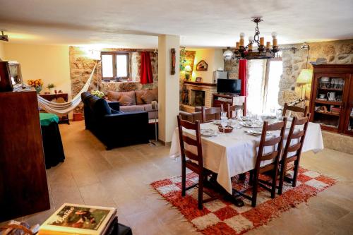 a dining room with a table and a living room at Casa das Lages in Viariz