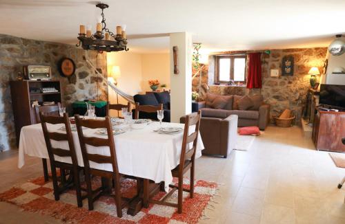 a dining room and living room with a table and chairs at Casa das Lages in Viariz