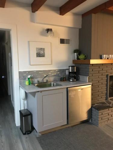 a kitchen with a sink and a stove at At Wits End B&B in Banff