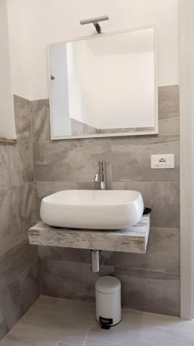 a bathroom with a white sink and a mirror at Eureka Room & Breakfast in Pietrapertosa
