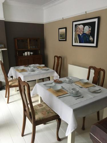 a dining room with two tables with dishes on them at Kings B&B in South Molton