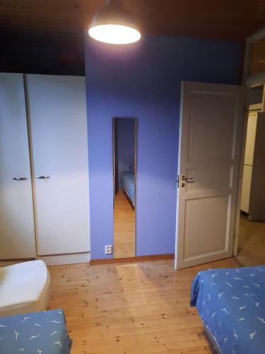 a room with two beds and a blue wall at vierashuone in Oulu