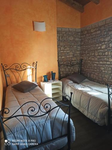 a bedroom with two beds and a stone wall at Casa Vacanze SoleLuna in Montichiari