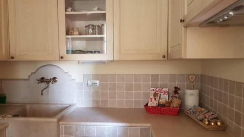 una cucina con armadi bianchi, lavandino e bancone di Casa Vacanze SoleLuna a Montichiari