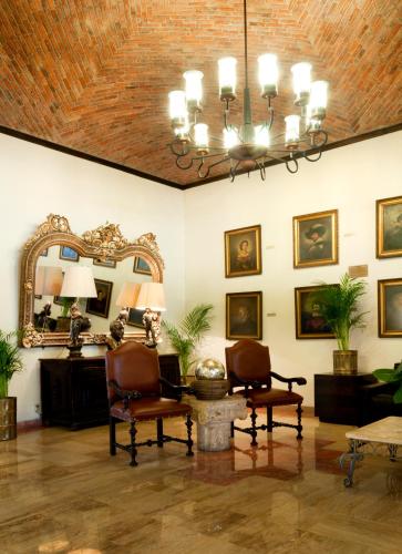 a living room with two chairs and a mirror at Real de Minas Poliforum in León
