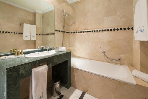 La salle de bains est pourvue d'une baignoire, d'un lavabo et d'une baignoire. dans l'établissement Eurostars Maimonides, à Cordoue