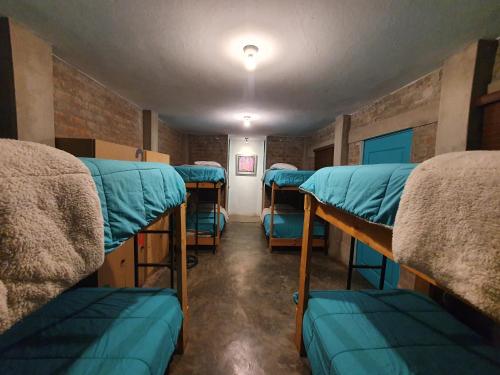 a room with four bunk beds in it at The Upcycled Hostel Huacachina in Ica