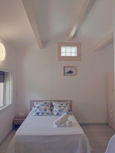 une chambre blanche avec un lit avec une fenêtre dans l'établissement STUDIO PRIVATIF CLIMATISÉ , TERRASSE ET PiSCINE, à Pernes-les-Fontaines