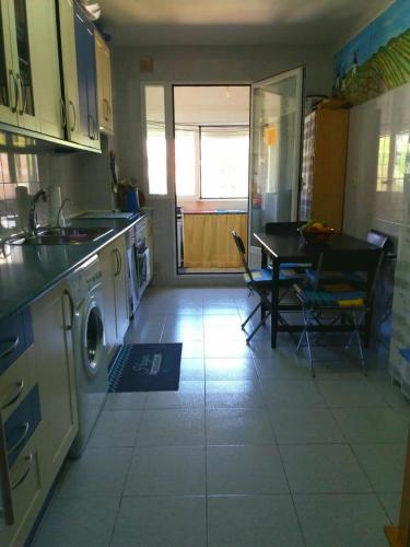 cocina con lavadora y mesa con sillas en Habitación para mujer, en Guadalajara
