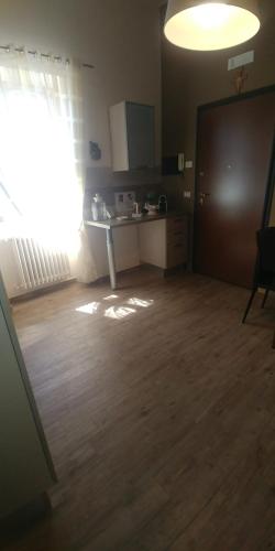 an empty room with a kitchen and a hard wood floor at Diadumeno Superior Apartment in Venosa