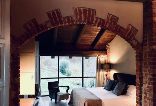 a bedroom with a bed and a large window at MiaClara Relais in Alba