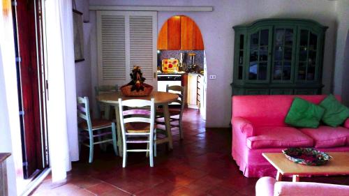 ポルト・チェルボにあるBeautiful Villa With Sea View to Porto Cervoのリビングルーム(ピンクのソファ、テーブル付)