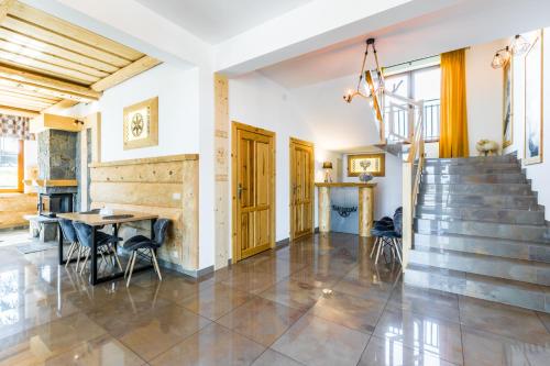a living room with a staircase and a table and chairs at Dom Wczasowy Tatrzański in Szaflary