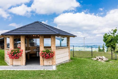 a wooden gazebo with flowers in a yard at Dom Wczasowy Tatrzański in Szaflary