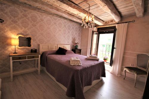 um quarto com uma cama, uma mesa e uma janela em Wabisabi Townhouse em Montejo de la Vega de la Serrezuela