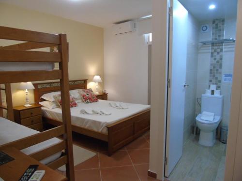 a small bedroom with a bunk bed and a toilet at Manta Guest - Bed & Breakfast in Manta Rota