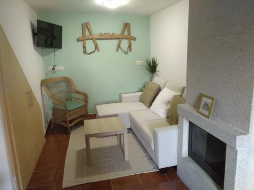 Casa Malvina في لا كورونيا: غرفة معيشة مع أريكة بيضاء ومدفأة