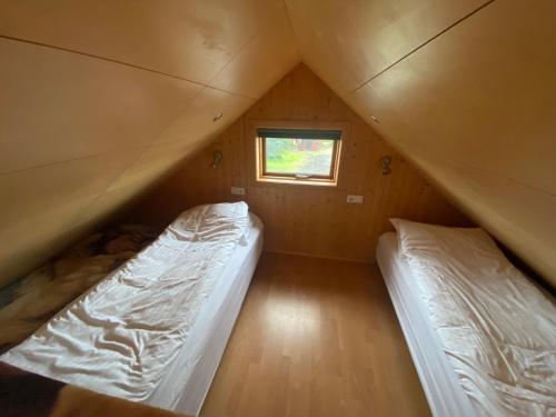 2 łóżka w małym pokoju z oknem w obiekcie Borgarbæli w mieście Hella