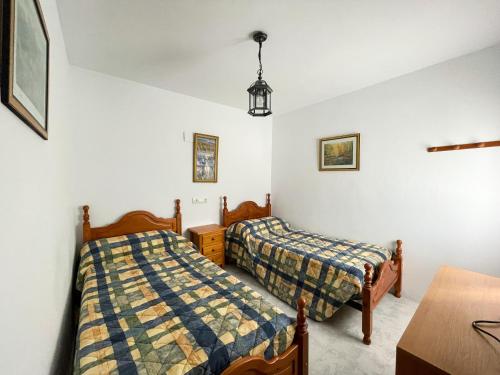 a bedroom with two beds and a table and a desk at Cortijo La Viñolilla en zona rural (Montefrío) in Montefrío