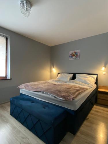 a bedroom with a large bed with a blue mattress at Apartament Artemida Kletno in Stronie Śląskie