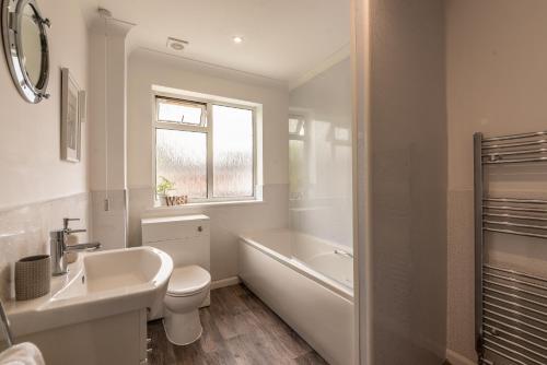 e bagno con lavabo, servizi igienici e vasca. di Luxury Southampton house with garden and parking a Southampton
