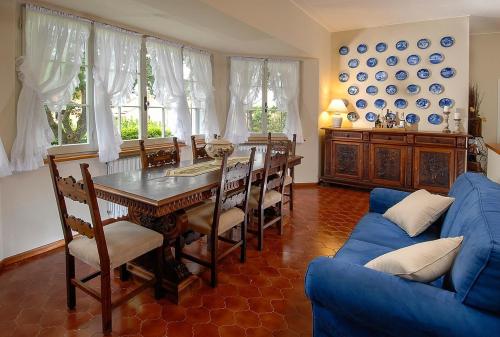 uma sala de jantar com uma mesa e um sofá azul em Villa La Paleotta em Fano
