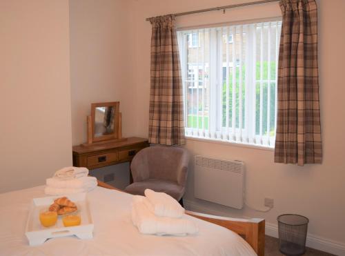 um quarto com uma mesa com uma cadeira e uma janela em Osprey Cottage, Manton in Rutland em Manton