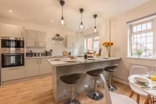 a kitchen with a large island with bar stools at 3 Bed Spacious Stylish House, Southampton - Off Road Parking & Private Garden - Sleeps 7, Close to City Centre - by Blue Puffin Stays in Southampton