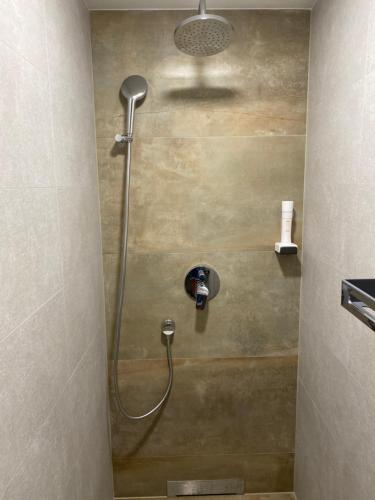 a shower with a shower head in a bathroom at Arletti Hotel in Ruse